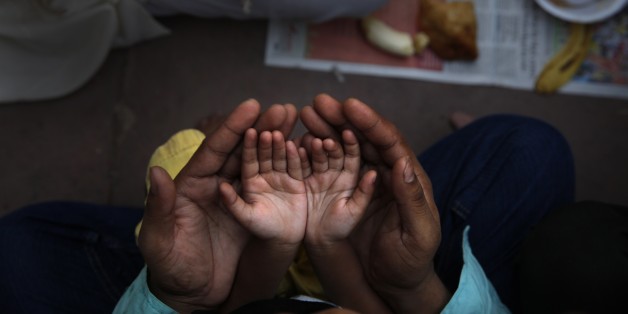 An Indian Muslim father holds the hands of his daughter in his palms and prays before  breaking fast on the first day of holy month Ramadan at the Jama Mosque in New Delhi, India, Monday, June 30, 2014. During this month the world's estimated 1.6 billion Muslims will abstain from food, drink and other pleasures from sunrise to sunset. (AP Photo /Manish Swarup)